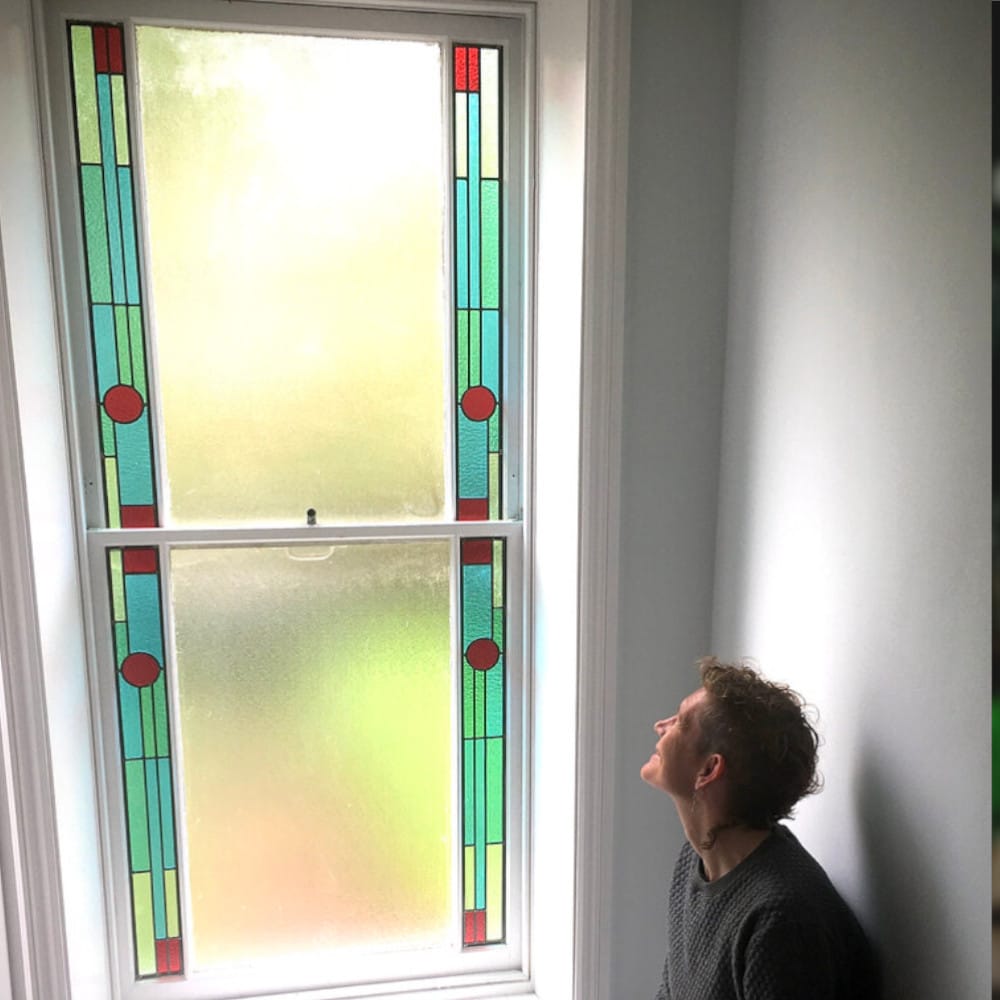 Anna Watson looking up at stained glass design in window